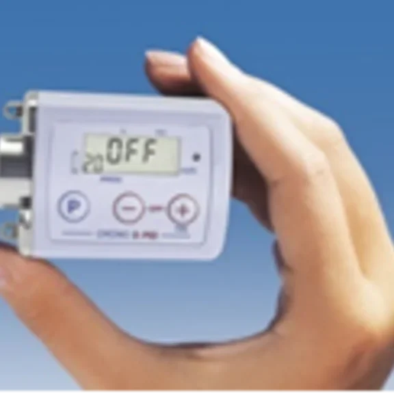 Kleine, draagbare Crono S-PID infusiepomp, perfect voor gebruik onderweg, getoond in de palm van een hand.