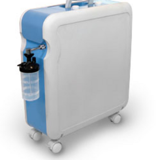 A rectangular, light blue and white portable Krober O2 oxygen concentrator with a humidifier bottle attached to the side, featuring a top handle and small wheels for mobility.