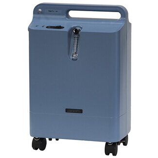 A medium blue, rectangular home oxygen concentrator with a top handle and wheels, featuring a visible flow meter and the "EverFlo" and "Respironics" brand names on the front.